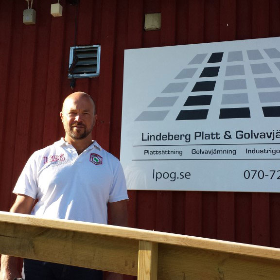 Pelle Lindeberg framför skylten för Lindeberg Platt & Golvavjämning AB i Åkersberga